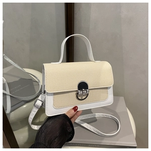 Detail of color-block shoulder bag with silver clasp, woven texture, and slim strap