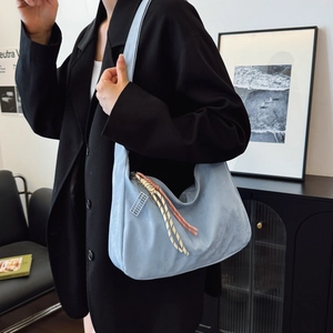 Light blue faux leather half-moon shoulder bag with woven pendant charm for women