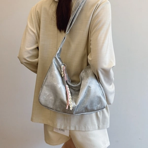 Silver metallic dumpling bag with textured finish and woven cord strap for women
