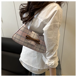 Close-up of pink plaid hobo bag featuring a leather bow and stylish shoulder strap