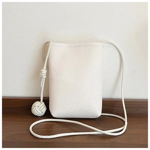 Close-up of white lychee pattern leather mobile phone bag with woven ball knot detail