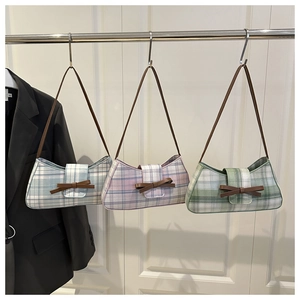 Three retro plaid underarm bags in blue, pink, and green with brown leather bow details