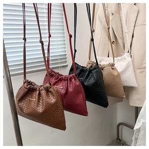 Détail de la texture tissée des sacs à cordon en plusieurs couleurs avec petit logo en métal