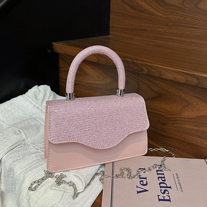 Rosa glitzernde Abendtasche mit silberner Kette auf minimalistischem Hintergrund