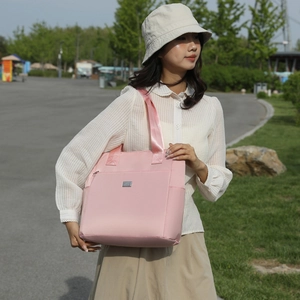 Pink large capacity Oxford tote bag for women shown in an outdoor casual setting