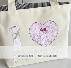 Close-up of off-white canvas tote bag featuring plushy heart print and striped lining