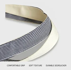 Detail of canvas tote bag handle with reinforced blue and white striped fabric stitching