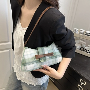 Green and white checkered underarm bag with a brown leather bow for casual street style