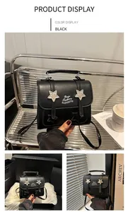 Detail of black crossbody bag featuring silver star studs and elegant top handle strap