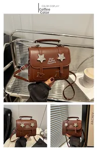 Detail view of coffee brown crossbody bag with star decor and metal accents