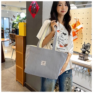 Close-up of grey-blue corduroy tote bag featuring fine ribbed texture and square fabric label