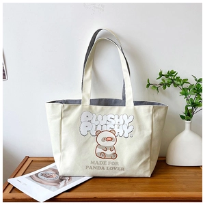 Detail of off-white canvas tote bag featuring cute panda print and striped interior lining