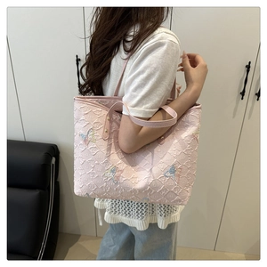 Detail of light pink tote bag with textured fabric and glittery butterfly embroidery