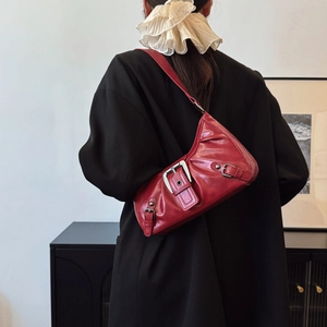 Vintage dark red leather shoulder bag with buckle details shown on model with black jacket