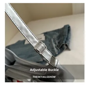 Detail of adjustable metal square buckle on silver metallic leather shoulder strap
