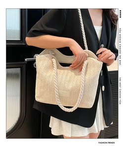 Détail du sac cabas en paille tissée avec étiquette logo et anse en corde de coton
