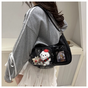 Détail du sac ita noir avec poche transparente montrant une peluche et un nœud en dentelle