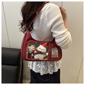 Détail du sac ita rouge avec fenêtre transparente et accessoires en peluche mignons
