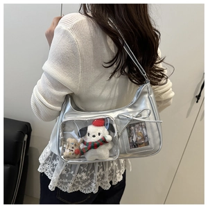 Détail du sac hobo en cuir verni argenté avec fenêtre transparente et peluches à l'intérieur