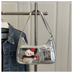 Detail view of silver PU shoulder bag featuring a clear window with dog plush and bow decor