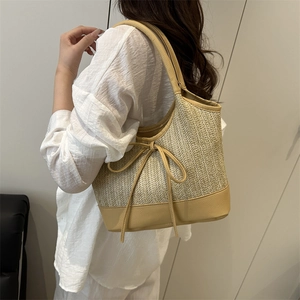 Große Boho-Stroh-Tote mit Lederbesatz und Schleifendetail an einem Modell gezeigt