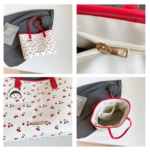 Detail view of cherry print tote bag featuring gold hardware and interior zipper pocket