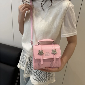 Pink star-patterned crossbody bag with silver buckles shown on a model for a trendy look