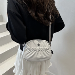 Minimalist cream crossbody bag with pleated design and wide shoulder strap for women