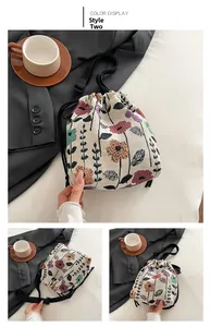 Detail view of floral jacquard bucket bag with drawstring closure and black strap