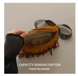 Detail view of brown suede fringe bag interior showing storage space for phone and wallet