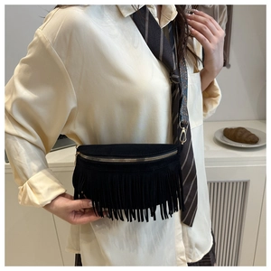 Detail of a bohemian black fringe bag with a geometric pattern wide strap and gold zipper