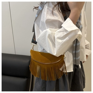 Detail of bohemian mustard yellow fringe crossbody bag with ethnic embroidered strap