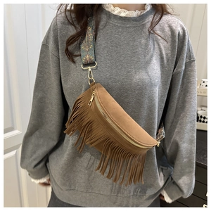 Close-up of brown suede tassel bag with bohemian floral jacquard wide strap and gold hardware