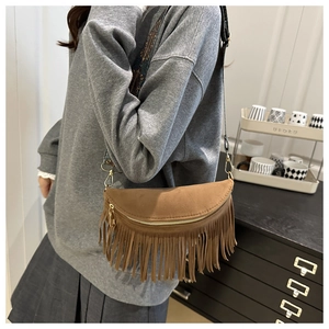 Detail of brown fringe crossbody bag with ethnic patterned wide strap and gold zipper