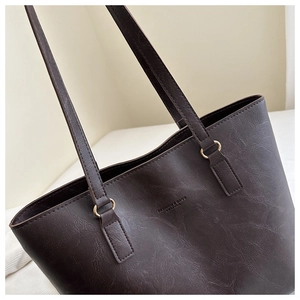 Close-up of brown tote bag with vintage leather texture and gold hardware rings