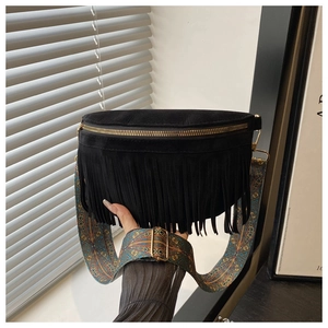 Detail of black suede fringe crossbody bag with ethnic embroidered strap and gold zipper
