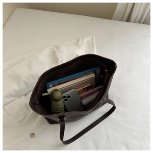 Spacious interior of dark brown leather tote bag with tablet and daily essentials