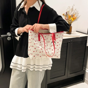 White cherry print tote bag with red handles and Chibi Maruko-chan charm detail