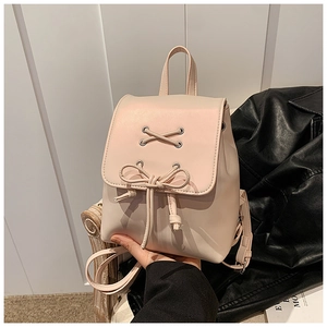 Detail eines rosa Mini-Rucksacks mit Schleifen-Kordelzug und silbernen Ösen auf Leder