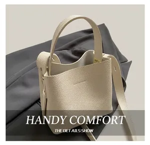 Détail du sac seau blanc crème avec texture en cuir grainé et rivets métalliques