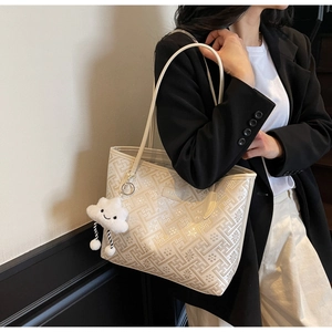 Detail of national style tote bag with geometric patterns and plush cloud charm