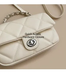 Détail du fermoir rotatif argenté et de la texture matelassée du sac à bandoulière beige