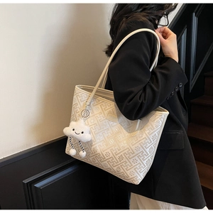 White tote bag with vintage geometric patterns and plush cloud charm on a shoulder strap