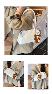 Detail of white oil wax leather handbag with CON CON logo and cute bear charm