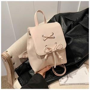 Detail eines rosa Kunstleder-Minirucksacks mit dekorativer Schleife und Tragegriff oben