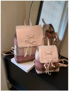 Detail eines rosa karierten Plüschrucksack-Sets mit Lederklappe und Schnürband-Design