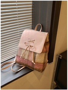 Detail eines rosa karierten Plüsch-Rucksacks mit Lederklappe und dekorativem Schleifen-Element