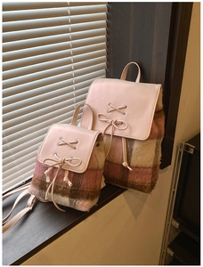 Detail eines rosa karierten Plüschrucksacks mit Schleife und PU-Lederklappe