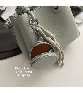 Dettaglio della borsa in pelle martellata verde chiaro con portamonete tondo rimovibile e cerniera