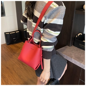 Sac seau en cuir grainé rouge porté en bandoulière avec poignées et sangle